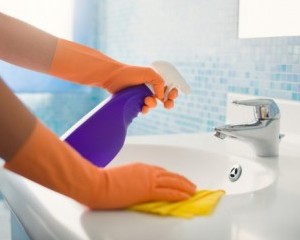 woman doing chores cleaning bathroom at home